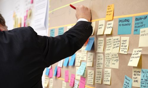 Individual writing on poster notes.