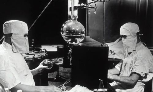 Two individuals experimenting in a lab sitting down. 